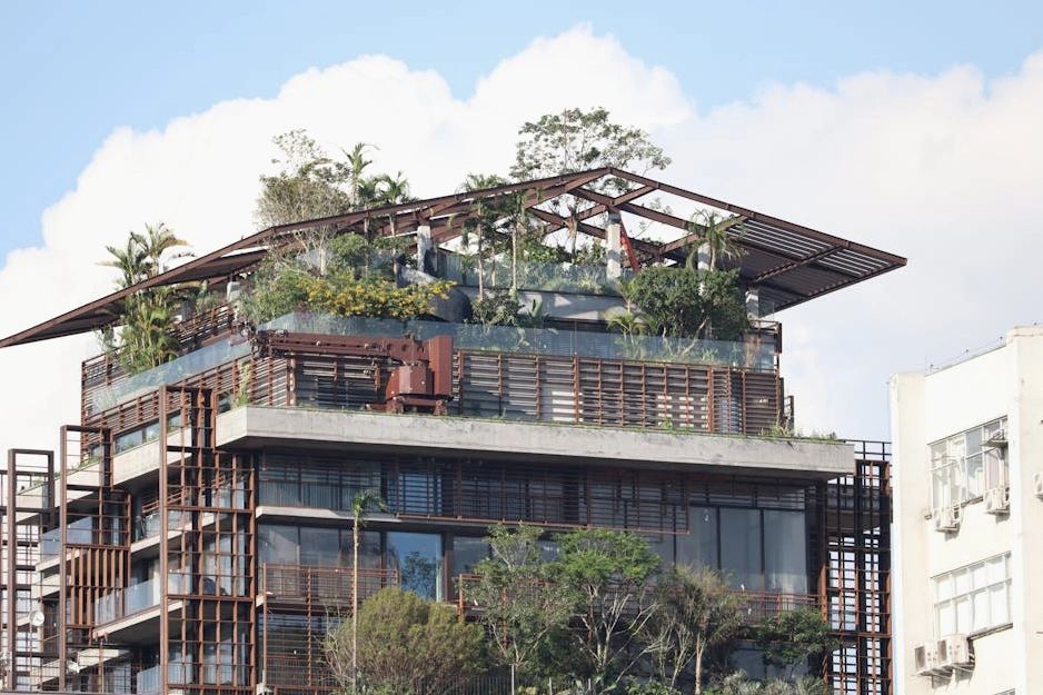 Nowoczesny, ekologiczny biurowiec otoczony zielenią.